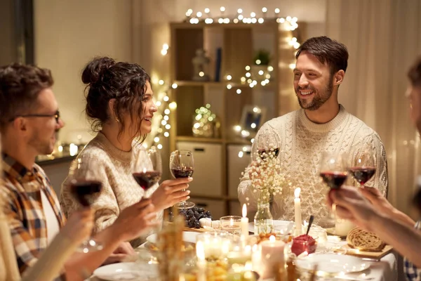 Щасливі друзі п'ють червоне вино на різдвяній вечірці — стокове фото