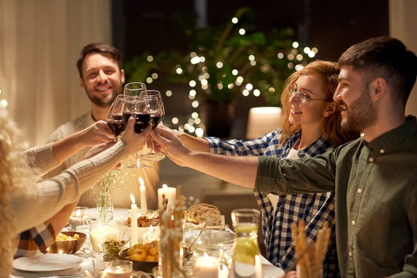 Amigos felices bebiendo vino tinto en la fiesta de Navidad —  Fotos de Stock