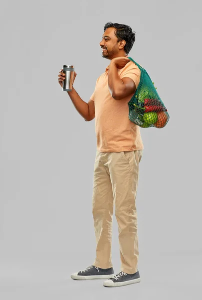 Man met voedsel in zak en tuimelaar of thermo cup — Stockfoto
