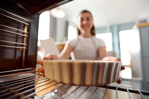Mujer cocina comida en el horno en casa cocina —  Fotos de Stock