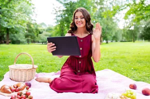 带平板电脑的妇女野餐时有视频通话 — 图库照片
