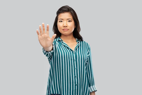 Asiatique jeune femme montrant arrêter geste sur gris — Photo