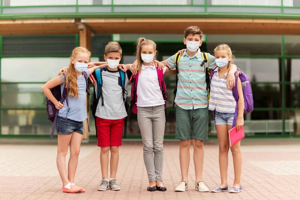 Grupa studentów w maskach przytulających się do szkoły — Zdjęcie stockowe