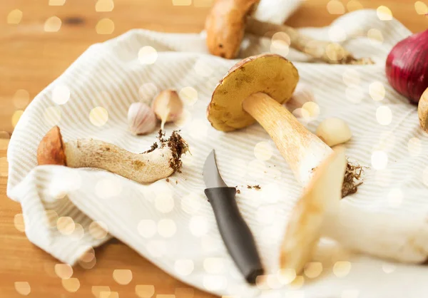 Eetbare paddenstoelen, keukenmes en handdoek — Stockfoto