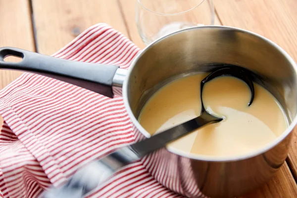 Olla con ponche de huevo y cucharón en toalla de cocina — Foto de Stock