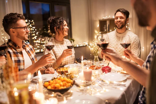 Happy friends drinking red wine at christmas party — Stock Photo, Image