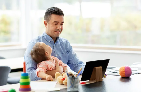 Pai com bebê trabalhando no PC tablet em casa — Fotografia de Stock