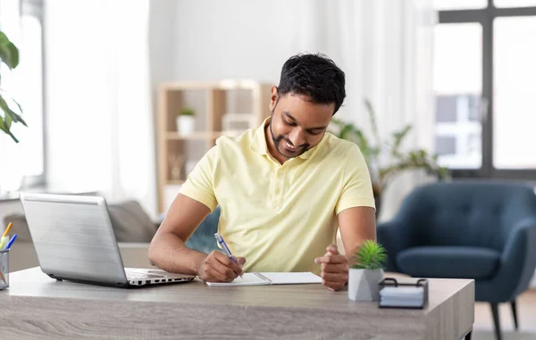 Indiaanse man met notebook en laptop op kantoor Rechtenvrije Stockfoto's