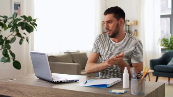 Mann benutzt Händedesinfektionsmittel im Home Office — Stockvideo