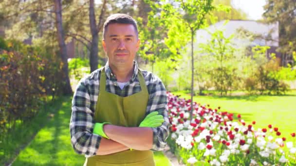 Boldog ember kötényben mutatja hüvelykujját a kertben — Stock videók
