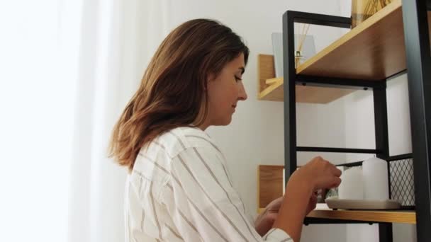 Woman with matchsticks lighting candles at home — Stock Video