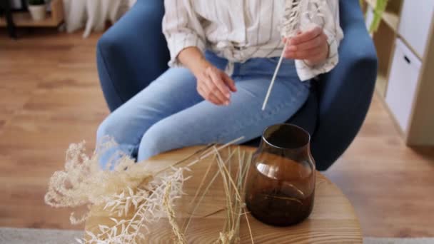 Woman arranging dried flowers in vase at home — Stock Video