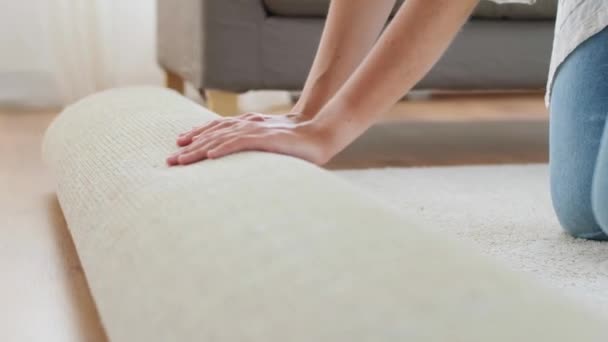 Jonge vrouw ontvouwt tapijt thuis — Stockvideo