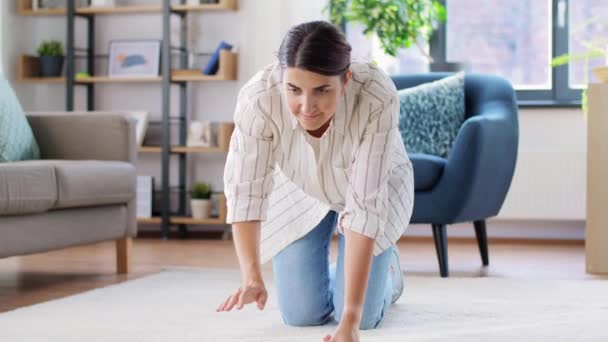Młoda kobieta rozkłada dywan w domu — Wideo stockowe