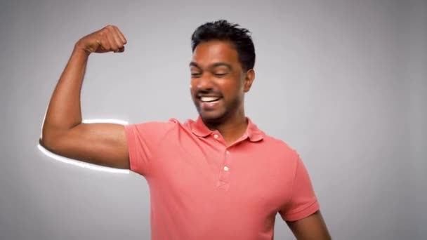 Homme indien montrant biceps sur fond gris — Video