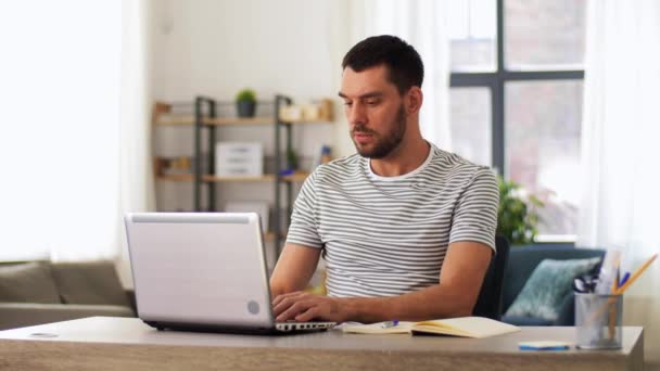 Pria dengan notebook dan laptop di kantor rumah — Stok Video