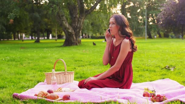 Kvinna ringer på smartphone på picknick i parken — Stockvideo