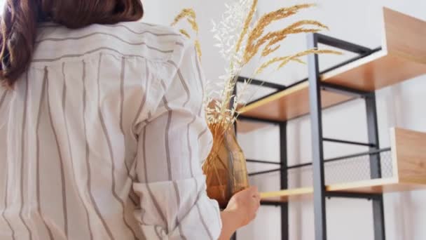 Vrouw versieren huis met gedroogde bloemen in vaas — Stockvideo