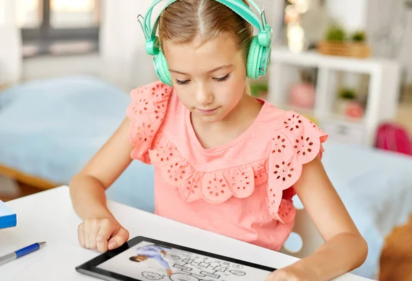 Dívka ve sluchátkách s počítačem tabletu doma — Stock fotografie