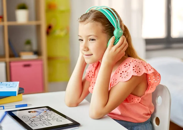 Meisje in hoofdtelefoon met tablet computer thuis — Stockfoto