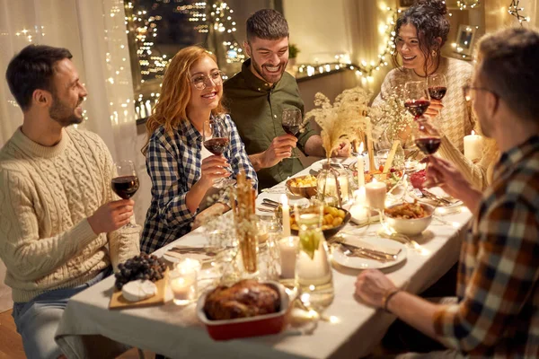 Šťastný přátelé pití červeného vína na vánoční párty — Stock fotografie