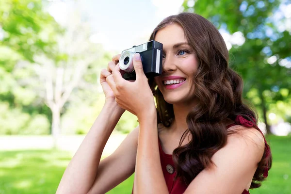 Lycklig kvinna med kamera fotografering i parken — Stockfoto