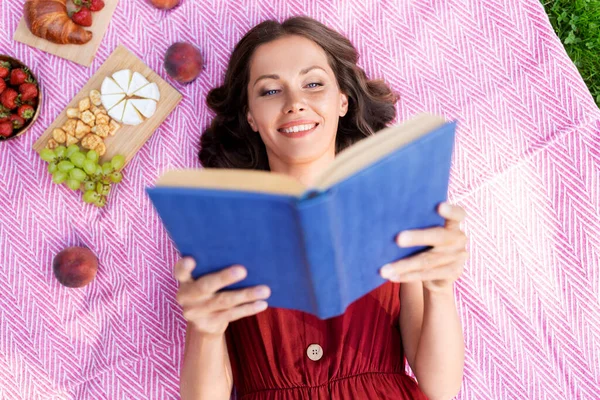Mulher feliz leitura livro no piquenique no parque de verão — Fotografia de Stock