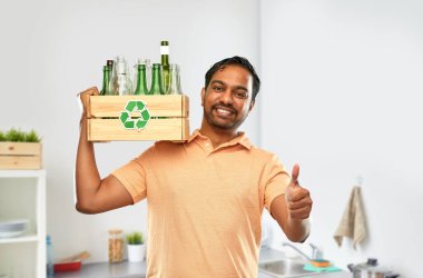 smiling young indian man sorting glass waste clipart