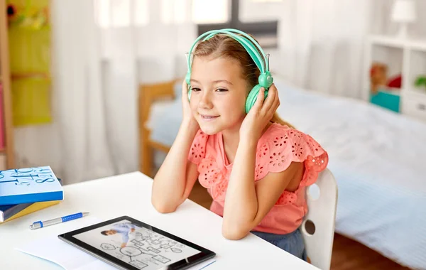 Dziewczyna w słuchawkach z tabletem w domu — Zdjęcie stockowe