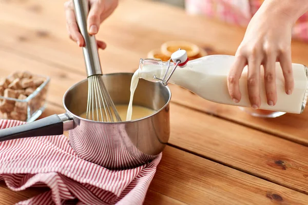 Mãos com batedor e ovo de cozinha de leite — Fotografia de Stock