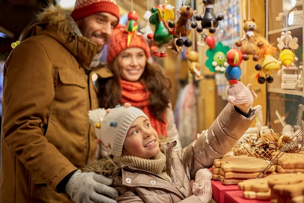 Щаслива сім'я купує сувеніри на різдвяному ринку — стокове фото