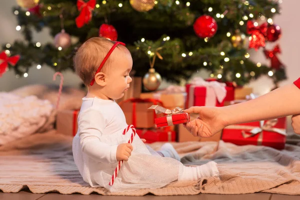 Liten flicka vid julgran med presenter hemma — Stockfoto