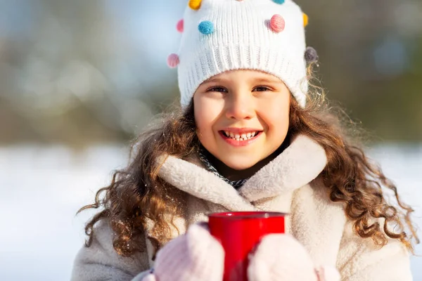 Klein meisje met kopje warme thee in de winter park — Stockfoto