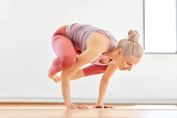 Jonge vrouw doen kraan poseren in yoga studio — Stockfoto