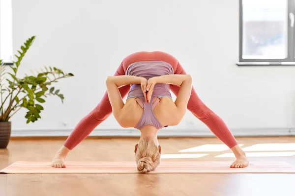 Mujer haciendo forward bend en yoga studio —  Fotos de Stock
