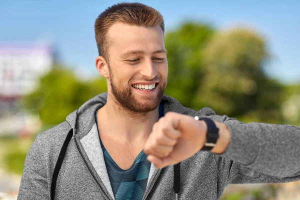 Hombre feliz con rastreador de fitness en la ciudad — Foto de Stock