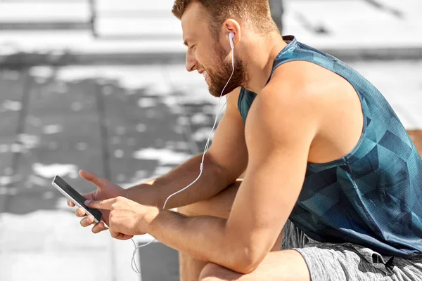 young athlete man with earphones and smartphone