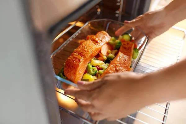 Mulher cozinhar alimentos no forno em casa cozinha — Fotografia de Stock