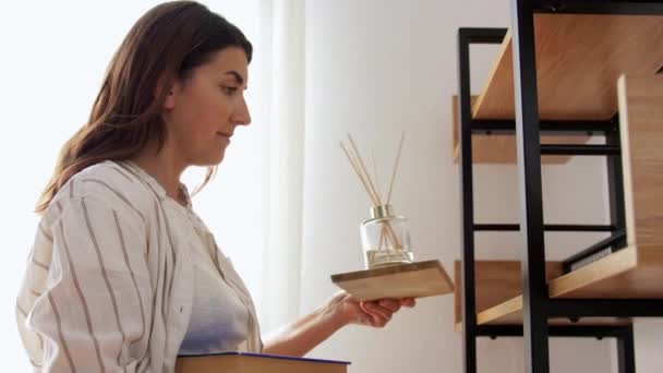 Woman placing aroma reed diffuser to shelf home — Stock Video