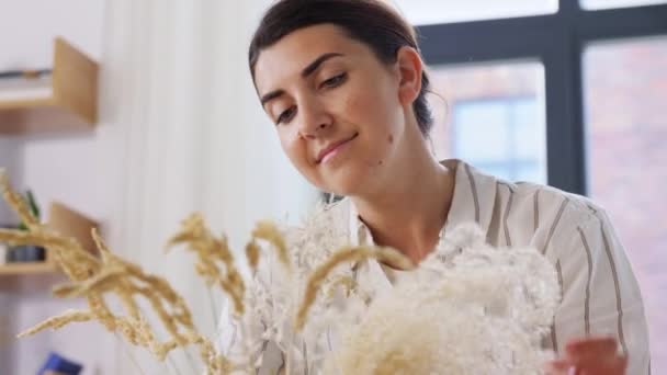 Woman arranging dried flowers in vase at home — Stock Video