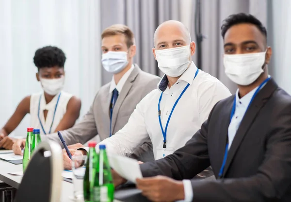 Obchodní lidé v maskách na setkání nebo konferenci — Stock fotografie