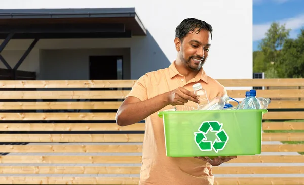 Улыбающийся молодой индиец сортирует пластиковые отходы — стоковое фото