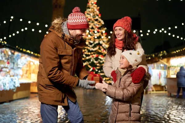 Famille heureuse avec cadeau au marché de Noël en ville — Photo