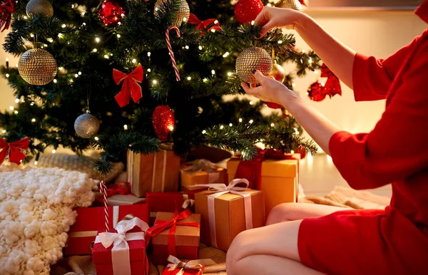 Mani che decorano albero di Natale con palla — Foto Stock