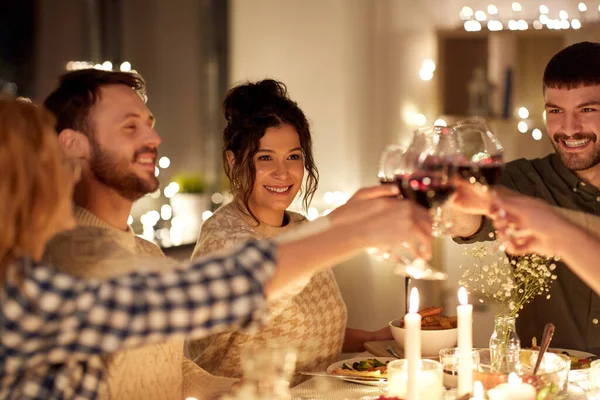 Mutlu arkadaşlar Noel partisinde kırmızı şarap içerler. — Stok fotoğraf