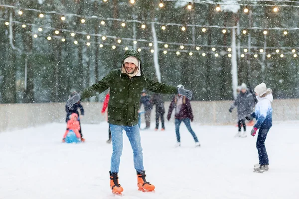 Jovem feliz no ringue de patinação ao ar livre no inverno — Fotografia de Stock