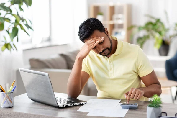 Man with calculator and papers working at home — Stock Photo, Image