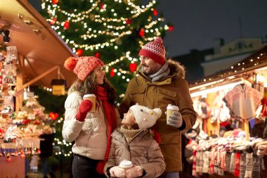 family with takeaway drinks at christmas market clipart