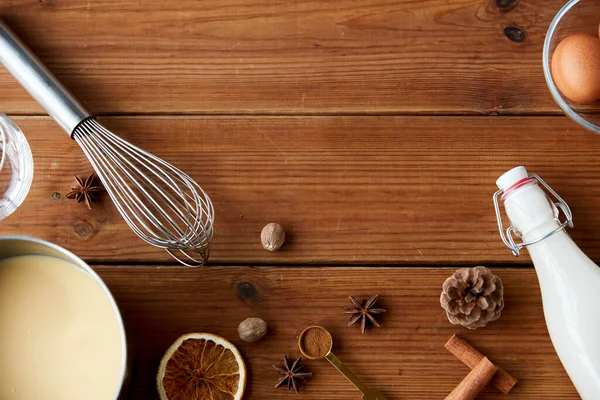 Pot with eggnog, ingredients and spices on wood — Stock Photo, Image