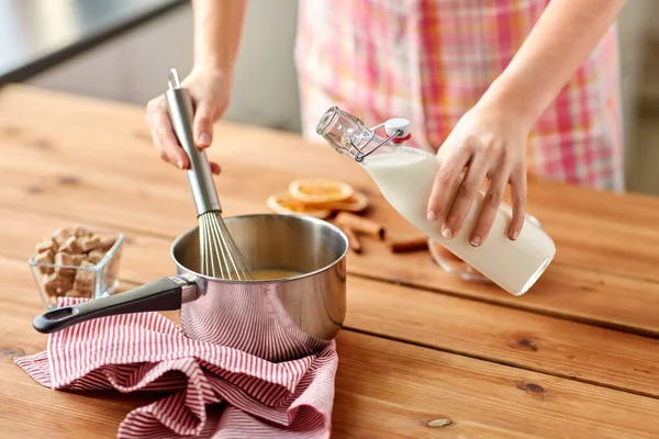 Händer med visp och mjölk matlagning äggtoddy — Stockfoto